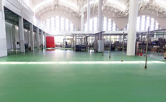 Grand hall de fabrication avec revêtement de couleur verte.