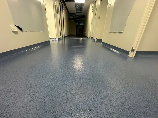 Sol en résine bleu dans un couloir avec plinthes relevées