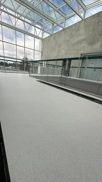 Grande salle éclairée avec sol gris en résine