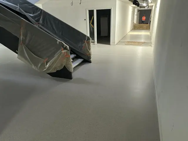 Sol en résine gris au pied d’un escalier dans un espace intérieur