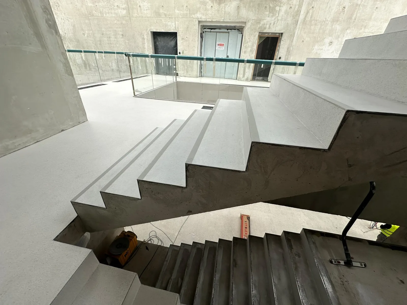 Escalier et paliers revêtus de résine grise dans un bâtiment public